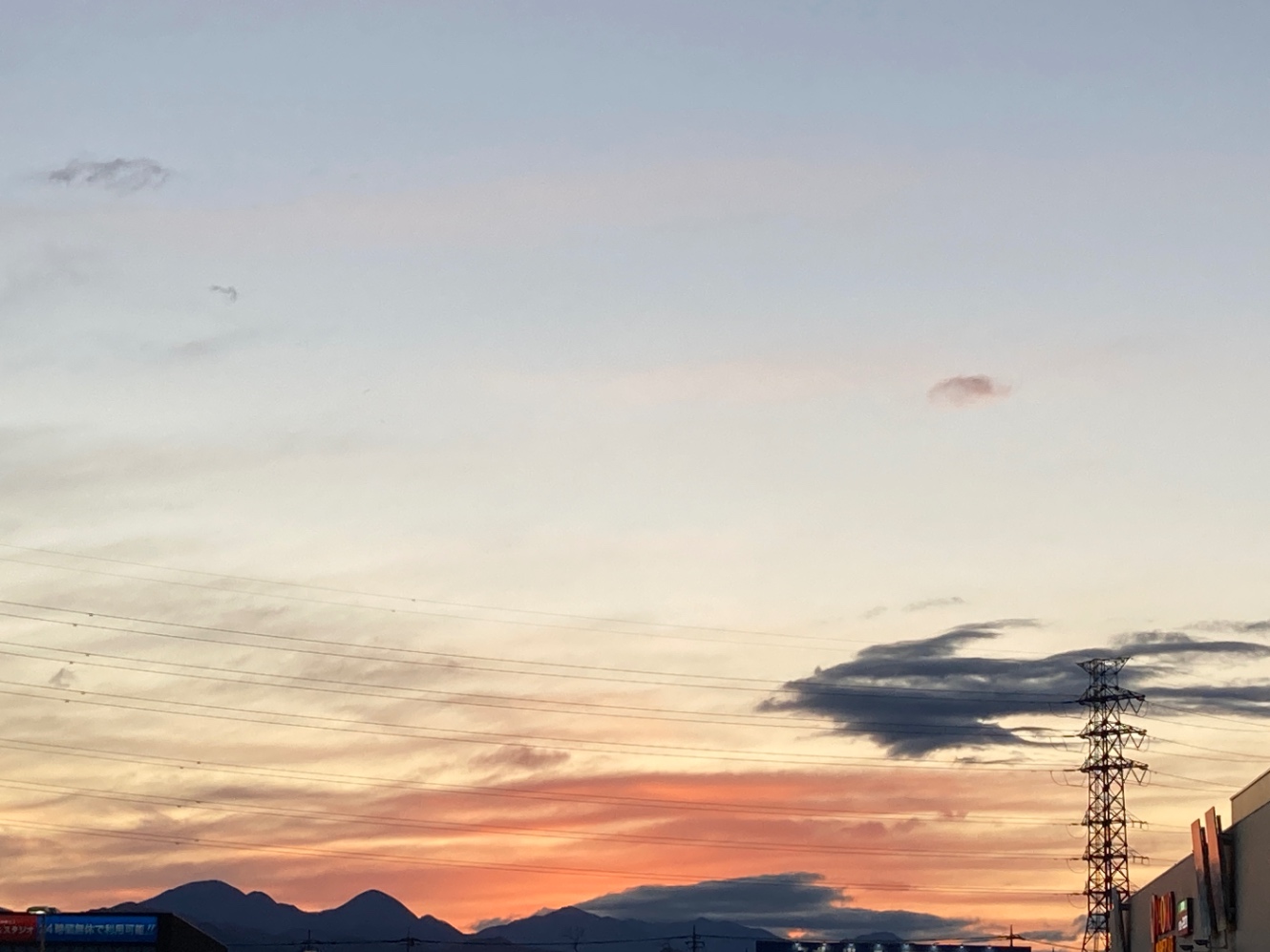 夕焼けの空。つばめのシルエットになった大きな雲がある写真。