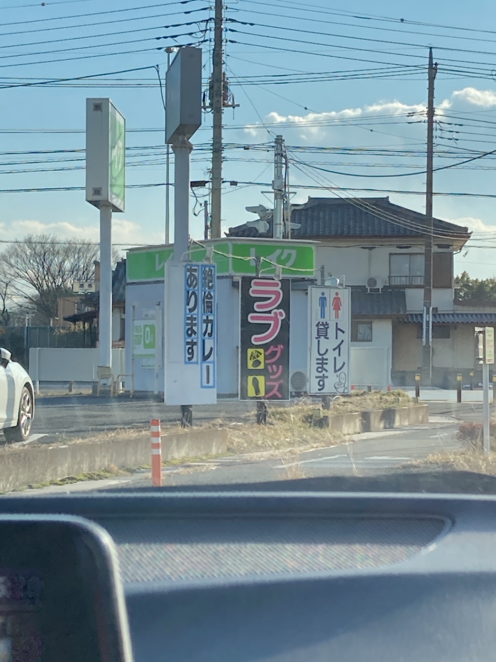 本庄17号沿いにあるアダルトショップの看板に「絶倫カレーあります」と書いてある写真。後ろにレイク。