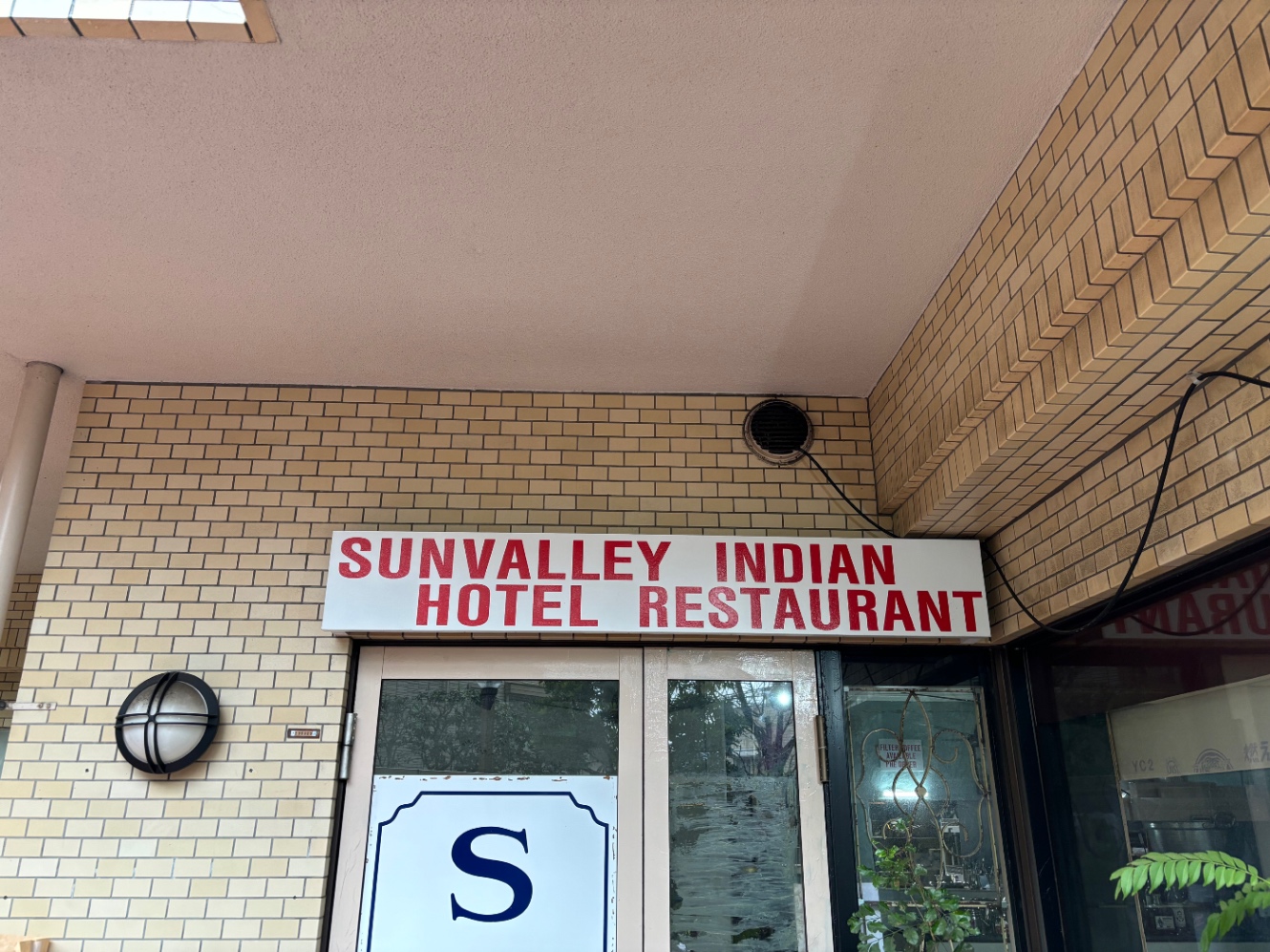 カレー屋の入り口　看板にSUNYALLEY INDIAN HOTEL RESTAURANTと書かれている