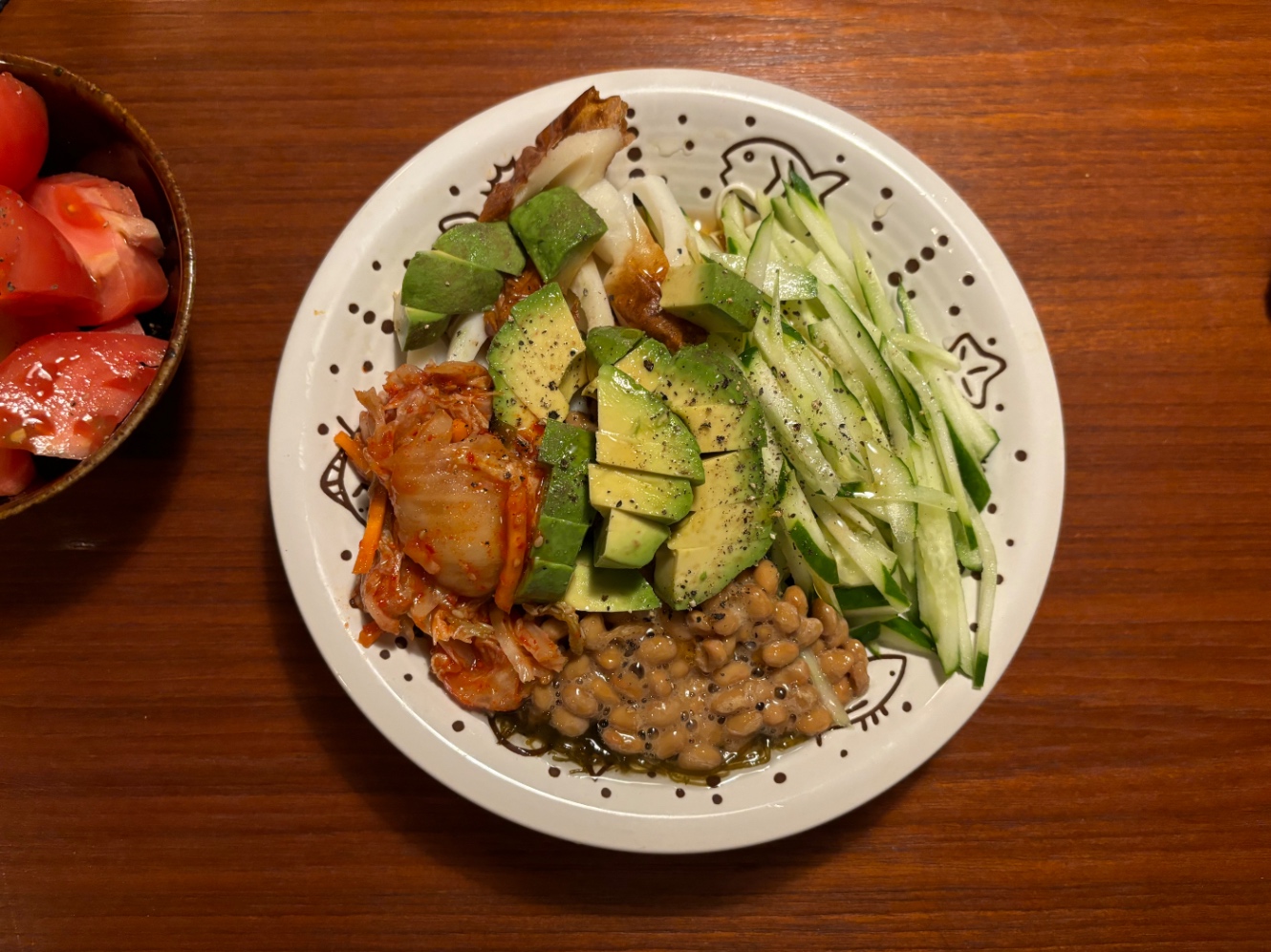 豆腐麺の上にきゅうりの細切り、アボカド、なっとう、キムチ、もずく、ちくわをのせたもの