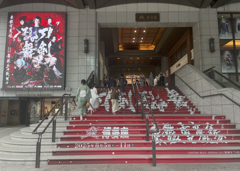 写真：博多座に続く入り口の階段、刀剣乱舞と書かれたポスターが掲げられている。