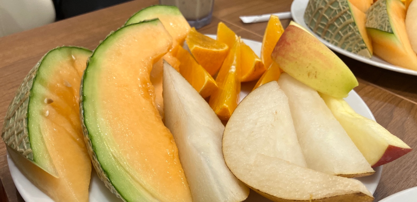 メロン、なし、りんご、オレンジが盛られた皿