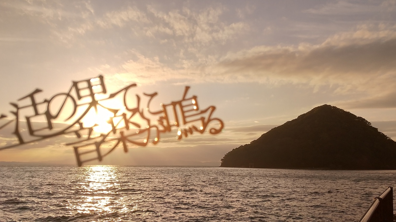 生活の果てに音楽が鳴るという文字で作られた金属の栞越しに見える夕日と青森市浅虫温泉湯之島