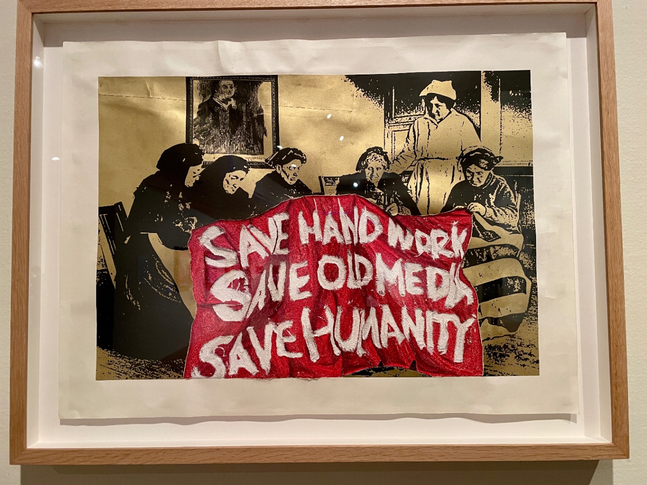 Save handwark save oldmedia save humanityと書かれた赤い布に何か刺繍している女性たち
