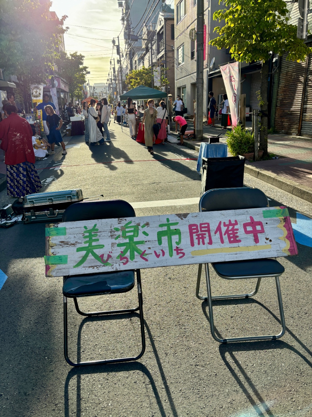 「美楽市開催中」の看板と祭りの様子