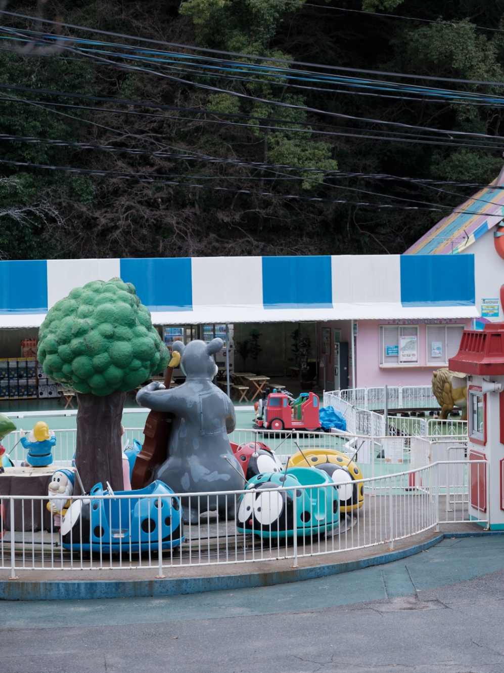 遊園地の写真。グレーのミッキーマウスのようなキャラの後ろ姿が見える。