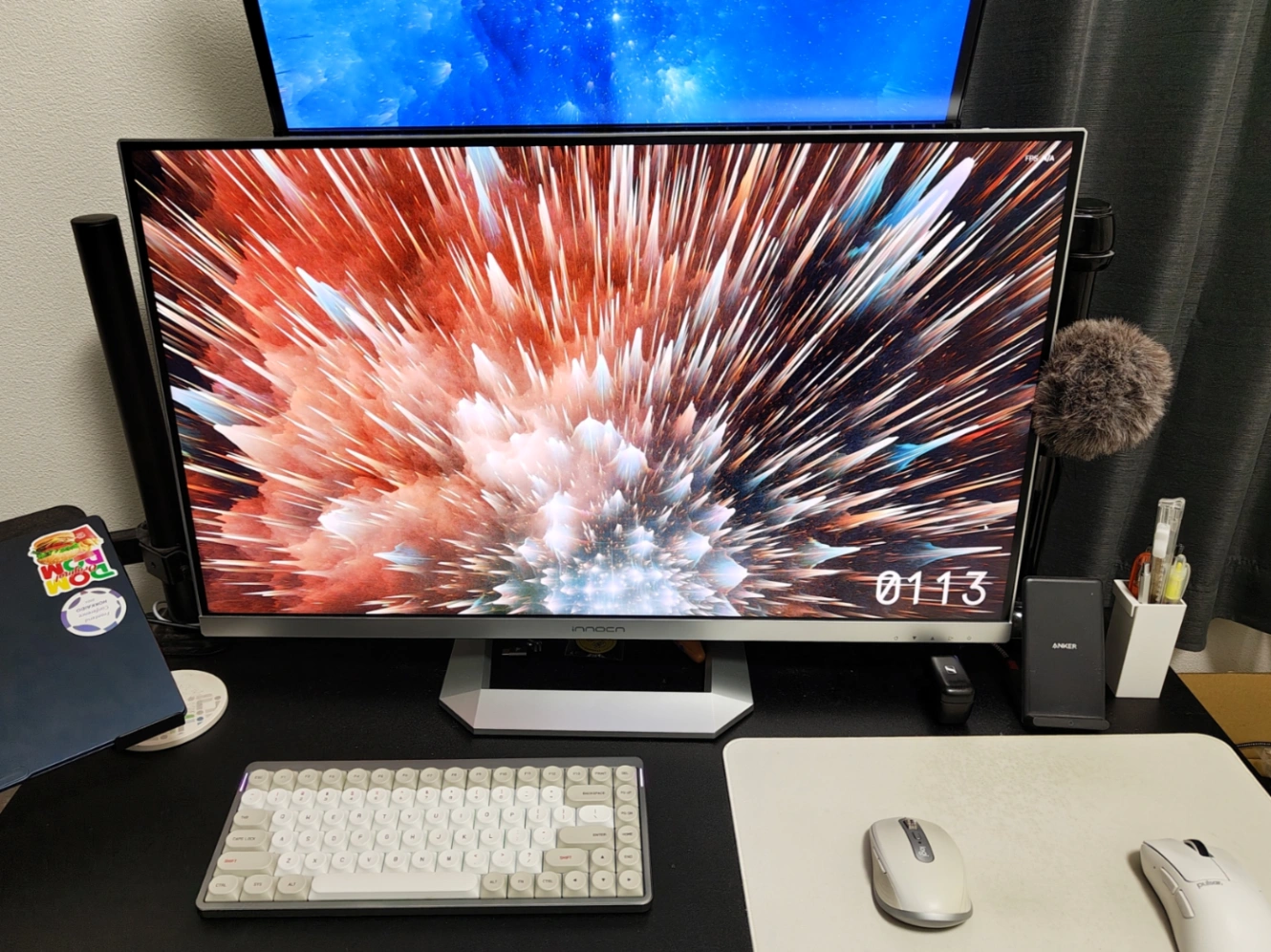 PCデスクを撮影した写真、画面中央に記事のタイトルにある銀色の4Kモニターがあり、周囲にマウスやキーボードも写っている。