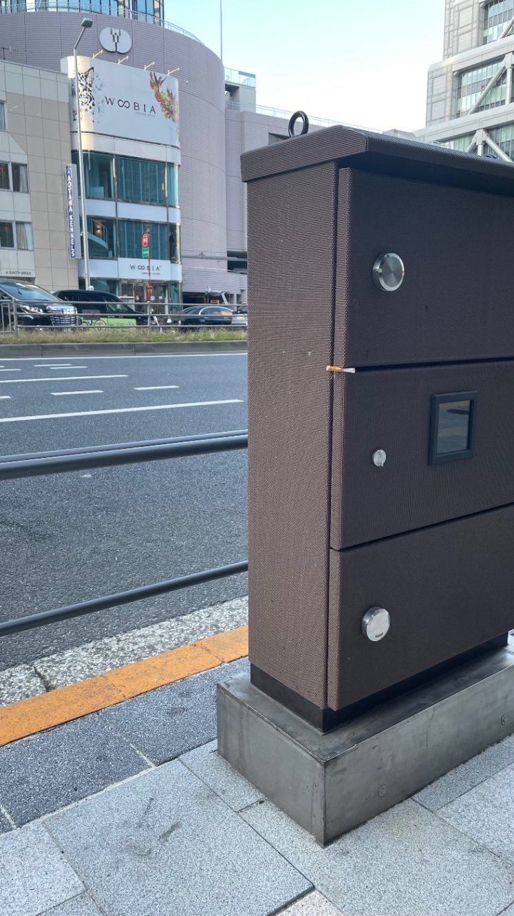 路上の配電盤の隙間にタバコが挟まっている