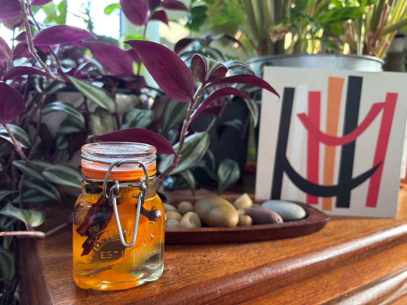 サイドボードの上に、クリップ式のジャー。クローブ、シナモン、オレンジピール入りの黄金色のシロップが入っている。