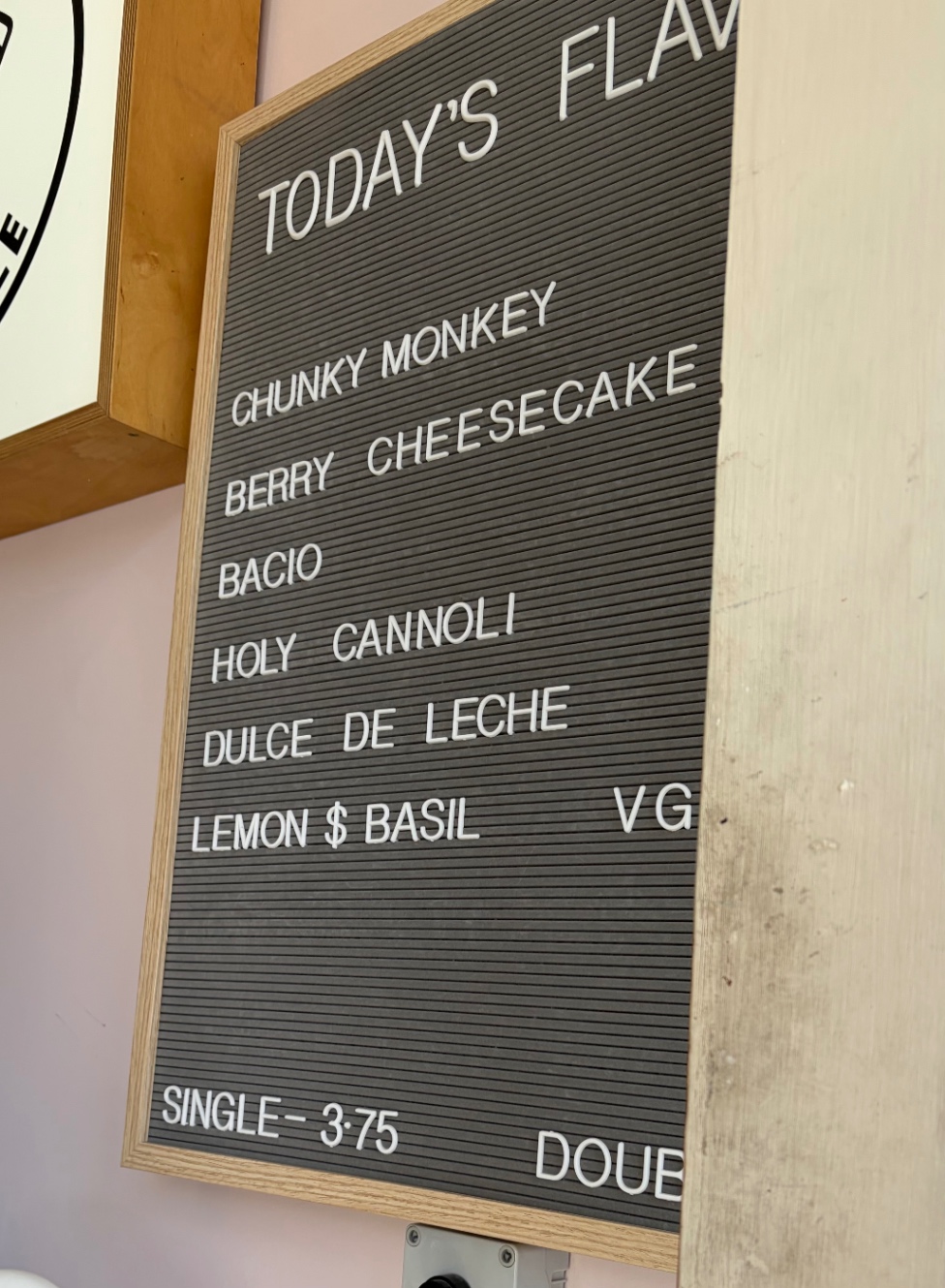 ジェラートのメニューボード。ベリーチーズケーキ、ドルチェデレチェ、レモン＆バジルなど。店員さんがジェラートをカップにぎゅうぎゅうに詰めてくれる。