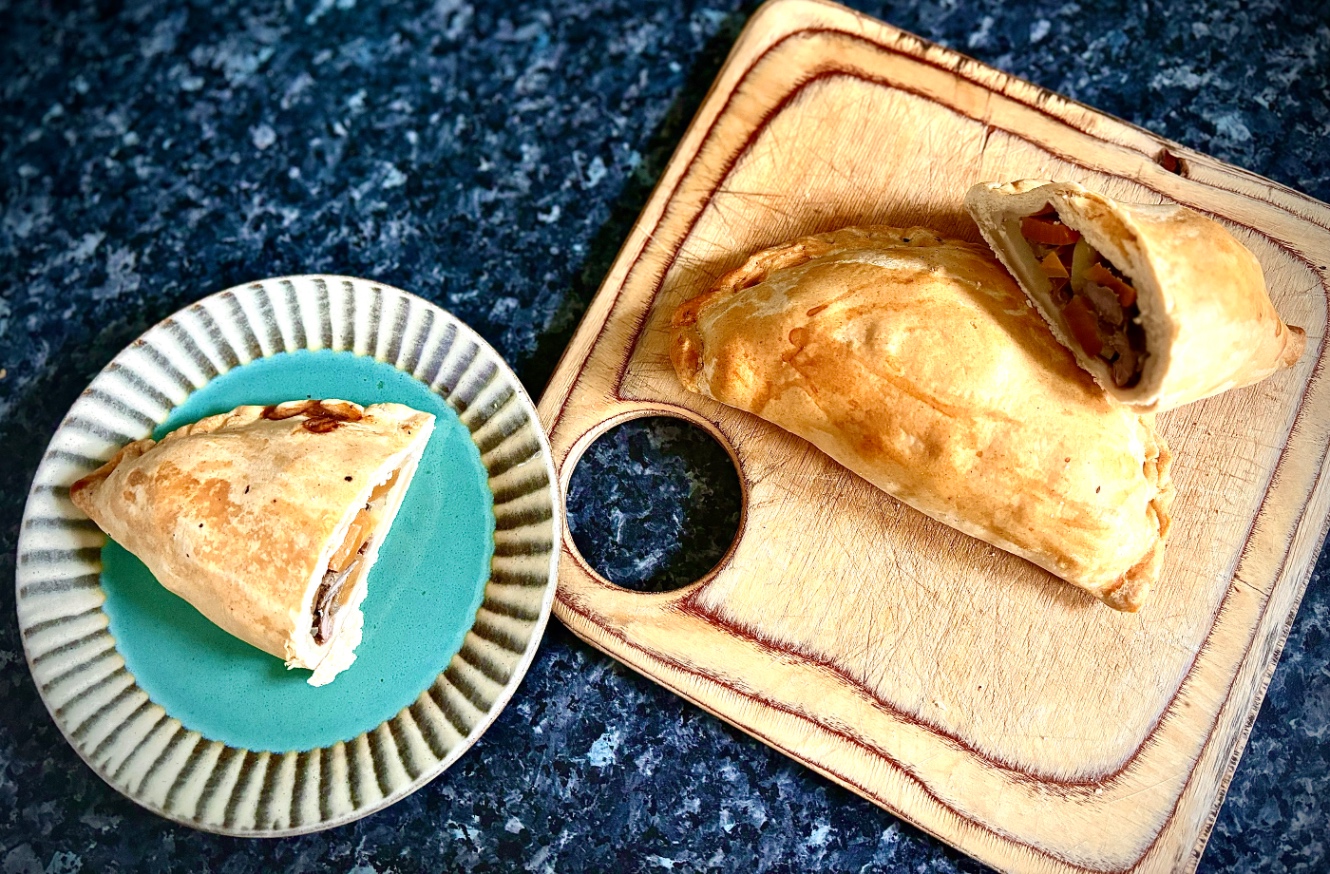 ペイストリー生地に肉と野菜などを包んで三日月型に成形してこんがり焼いたおかずパイ。