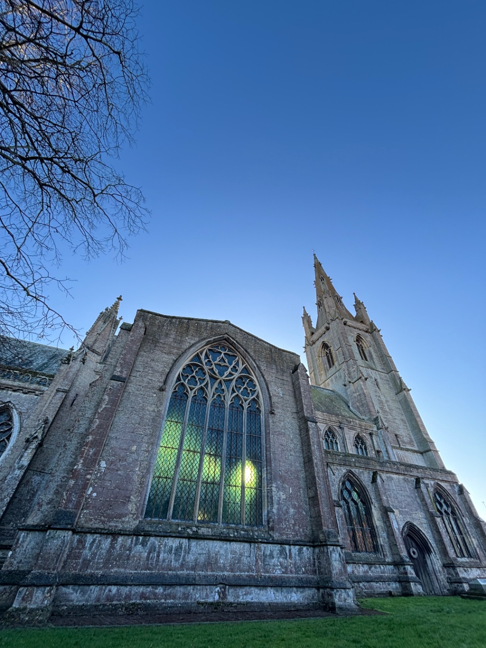 ゴシック様式の教会。ステンドグラスの窓からエメラルド色の光が漏れている。