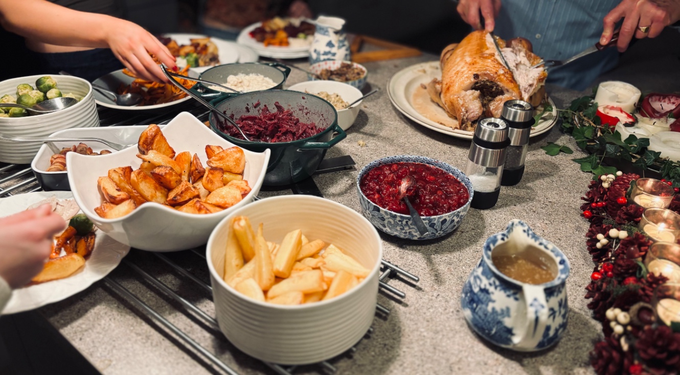 クリスマスディナーを取り分けているところ。レッドキャベツ、ローストポテトにパースニップ、クランベリーソース、芽キャベツなどが並びます。義父がターキーを切り分けてくれます。