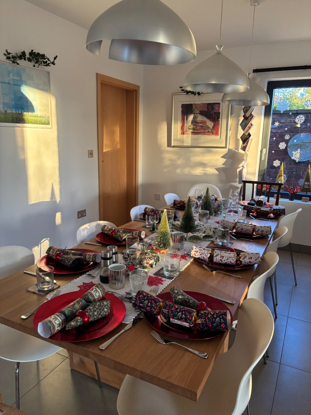 クリスマスクラッカーやミニチュアツリーなど、季節を感じさせるフェスティブなデコレーションをほどこしたディナーテーブル。