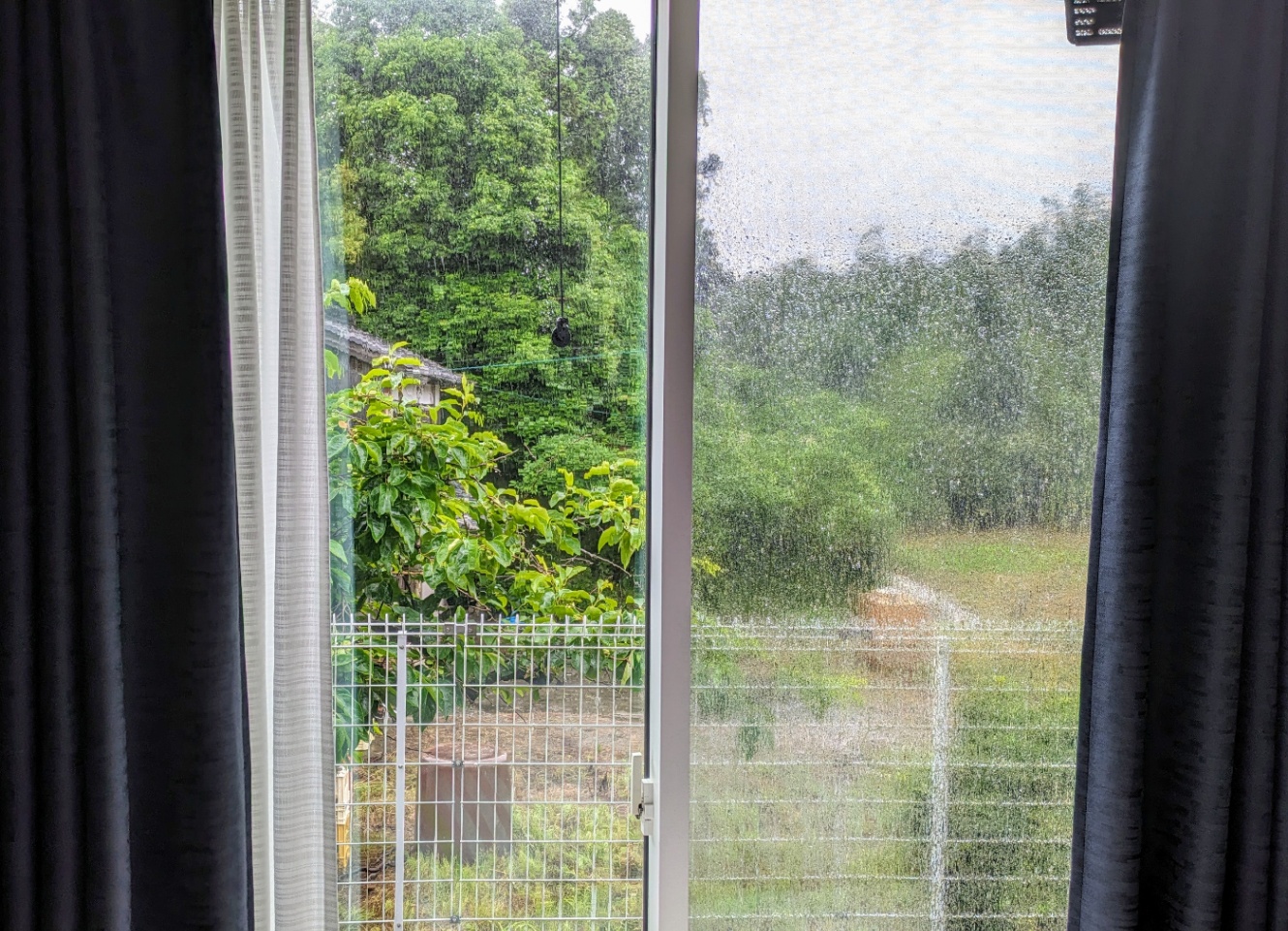 自室の窓から見た外の景色。雨が降ってる