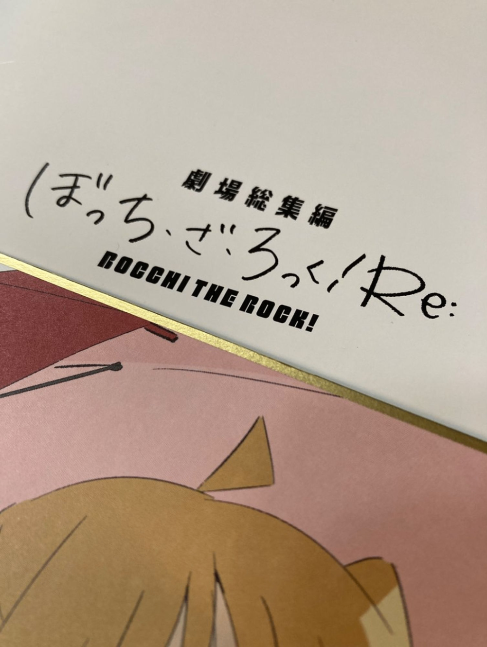 『劇場総集編ぼっち・ざ・ろっく！Re:』のリーフレットと特典の色紙にプリントされた伊地知虹夏の頭頂部。