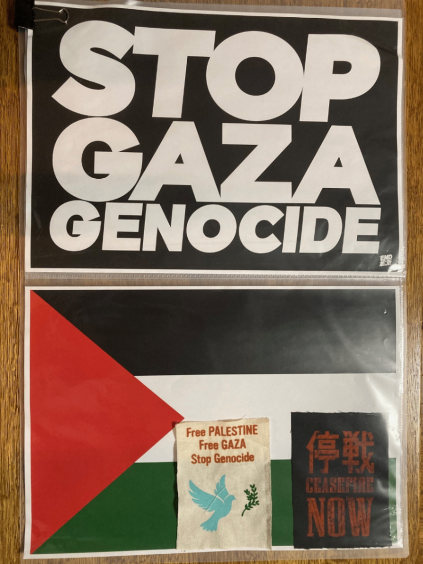 プラカード。上が「STOP GAZA GENOCIDE」下がパレスチナ国旗と、その下部に水色の鳩が印刷されたパッチと、右下に「停戦NOW」のパッチ。