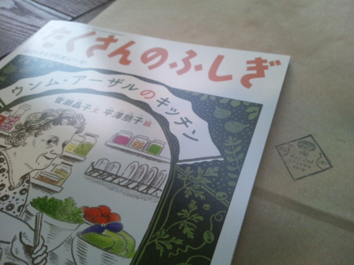 橙書店の紙袋と、その上に『月刊たくさんのふしぎ６月号　ウンム・アーザルのキッチン』菅瀬晶子 文,平澤朋子 絵