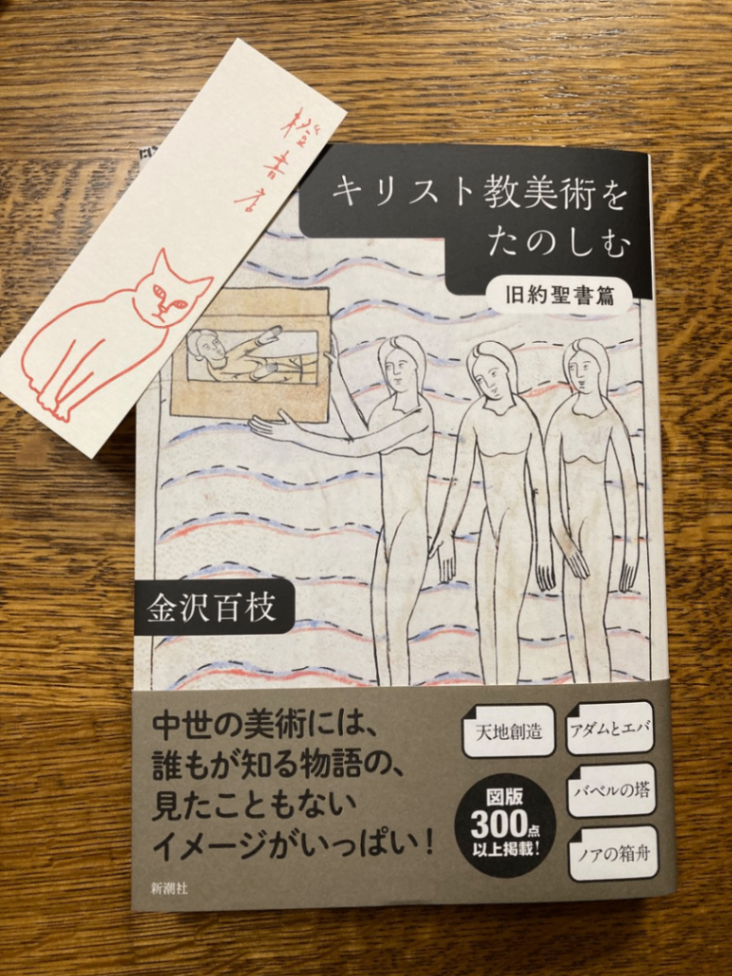 金沢百枝　著『キリスト教美術をたのしむ　旧約聖書篇』の本。本の左上は猫のイラストがあしらわれた橙書店のしおり。