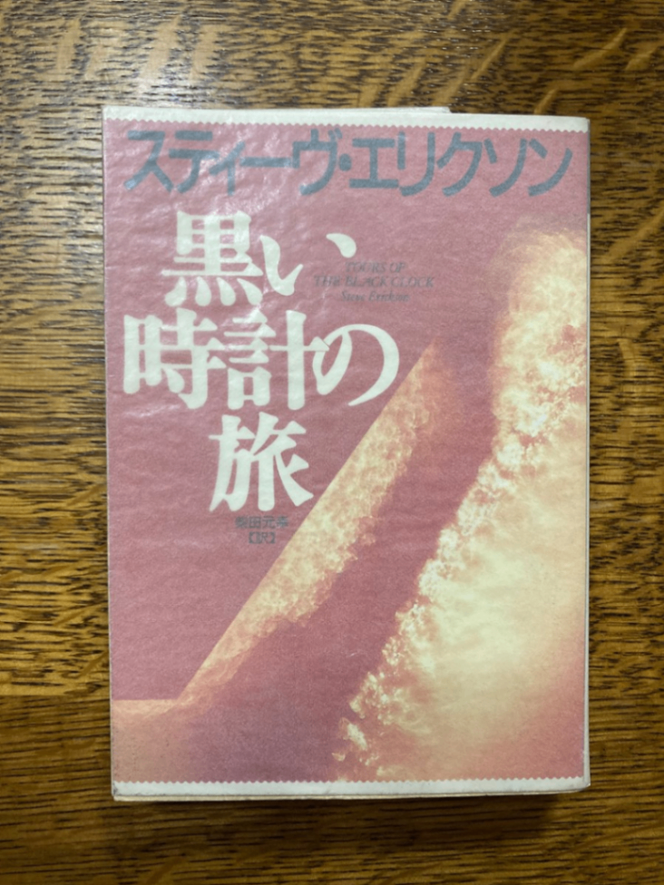 スティーヴ・エリクソン『黒い時計の旅』の文庫本赤い表紙。タイトルは白い文字。著者名は黒。薄い紙がかけられています。