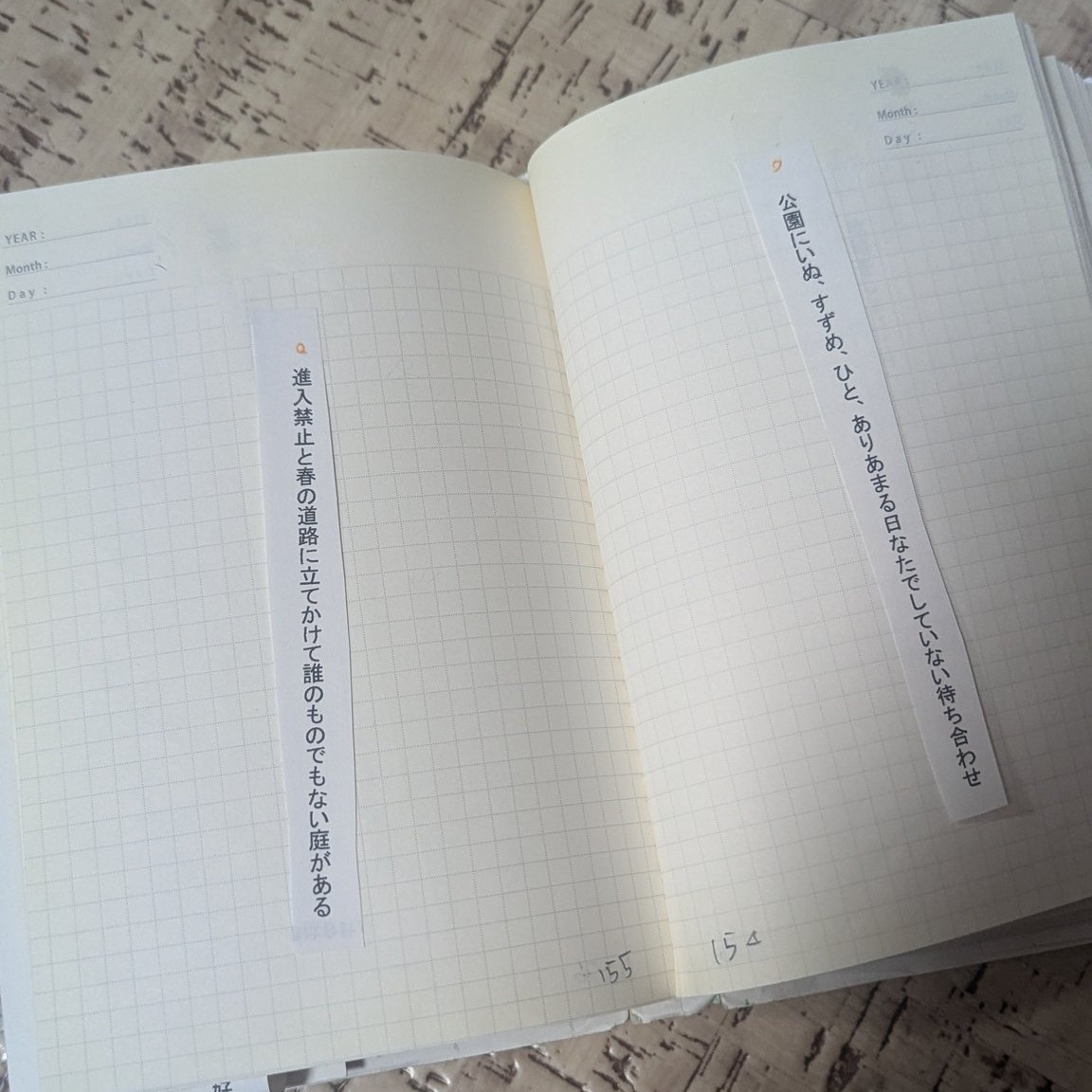 構成用ノートの写真　１ページに１首短歌短冊を貼ってある