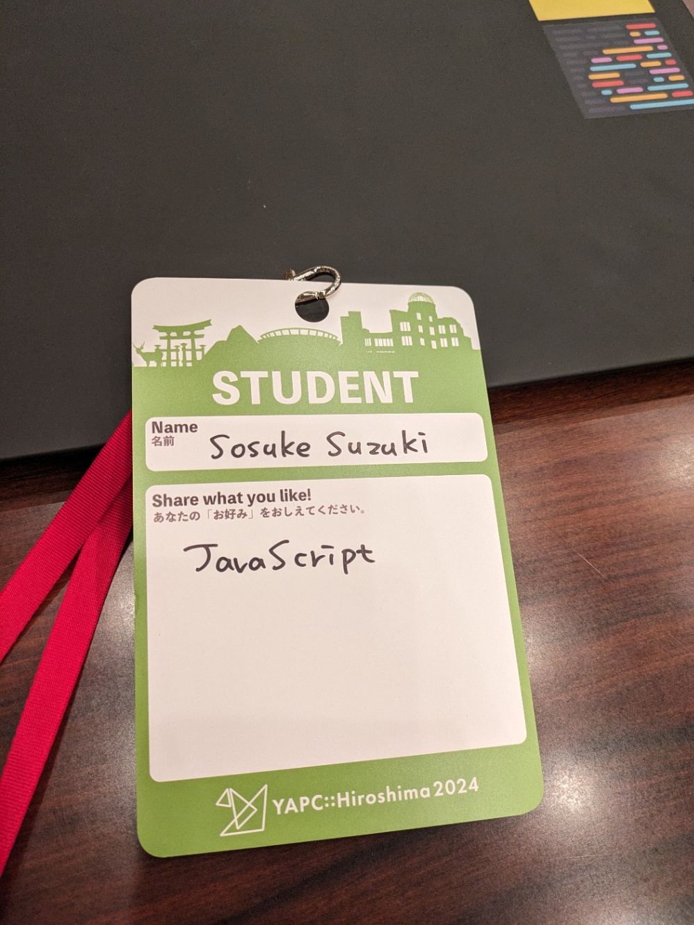 黄緑色のネームカード。Name欄にはSosuke Suzukiと書かれている。Share what you like 欄には JavaScript と書かれている。