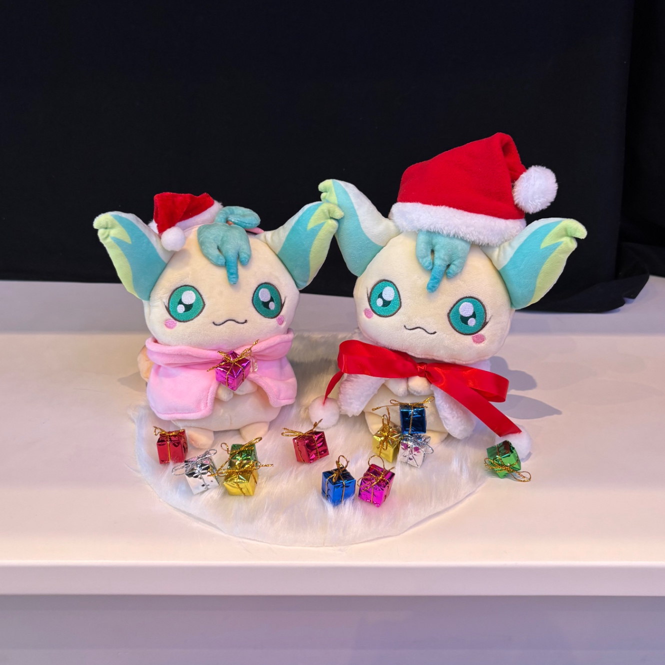 サンタ帽を被ったパドドゥ？のぬいぐるみが2匹並んでいる画像。手前に小さなクリスマスプレゼントの箱が並べられている。
