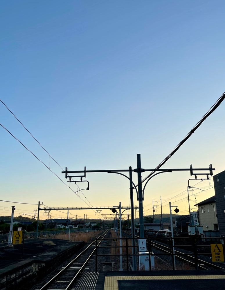 夕暮れの始まっている空と、まっすぐ伸びていく線路