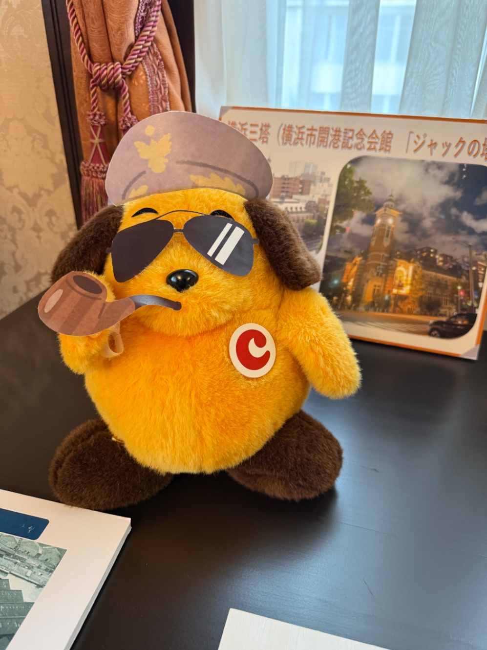 カスタム君のぬいぐるみがサングラス、軍帽、パイプの小道具で装飾されている