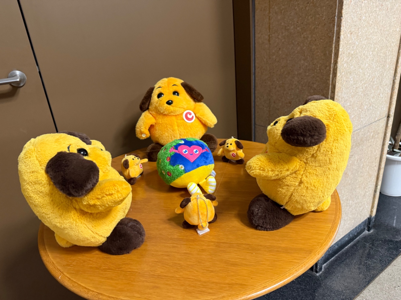 大小のカスタム君たち(8体)が地球のキャラを模したぬいぐるみを囲んでいる