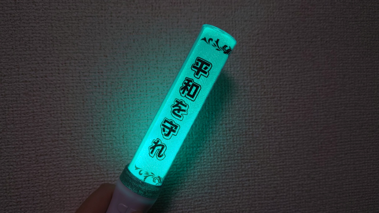 平和を守れと書かれ、エメラルドグリーンに光る500円のペンライト