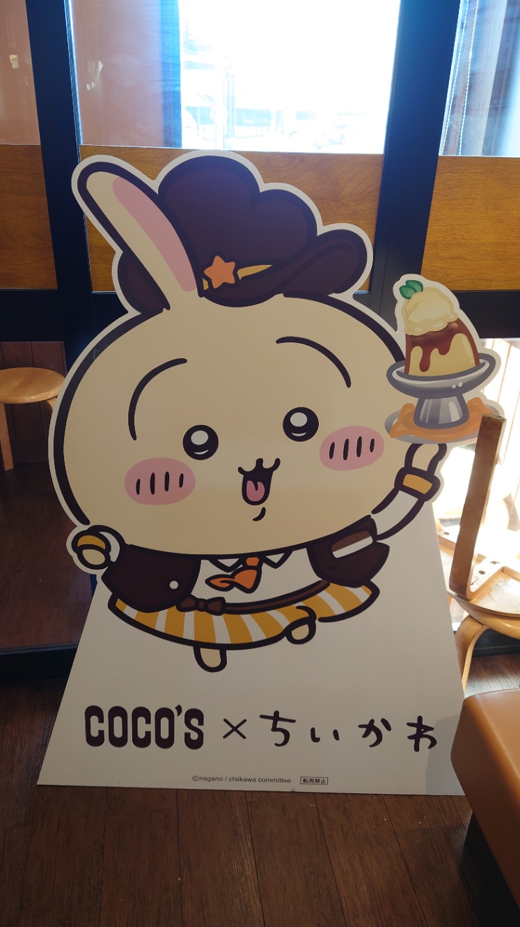 COCO'S×ちいかわ ちいかわのうさぎのポップアップスタンド。 カフェ店員らしき服装に、プリンをもっている。