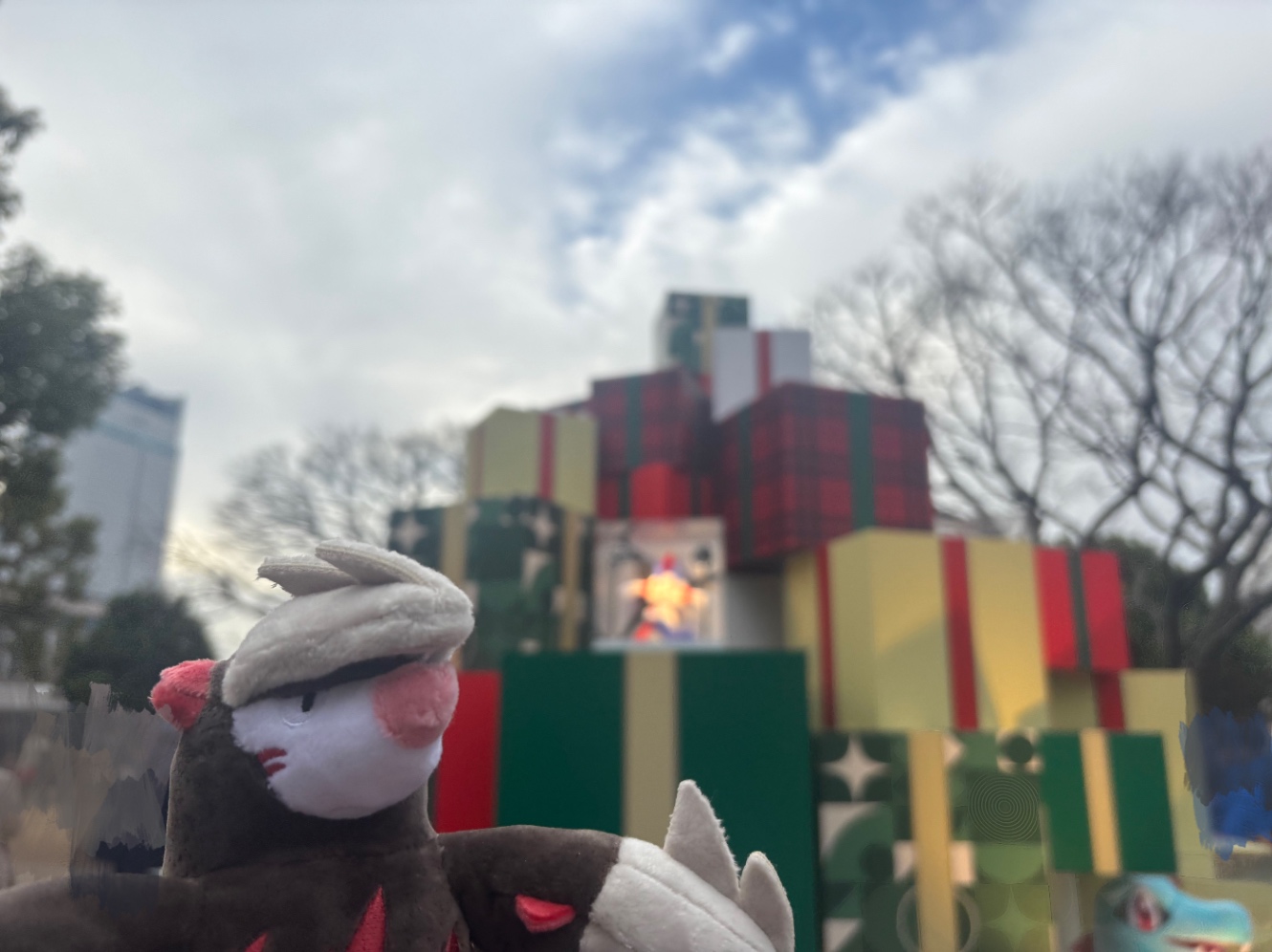 横浜赤レンガ倉庫のポケモンブースにある大きなプレゼントボックスが積まれた展示品の写真。プレゼントボックスには今年発売のぬいぐるみが飾られています。手前にPokémon fitのドリュウズのぬいぐるみが写っています。