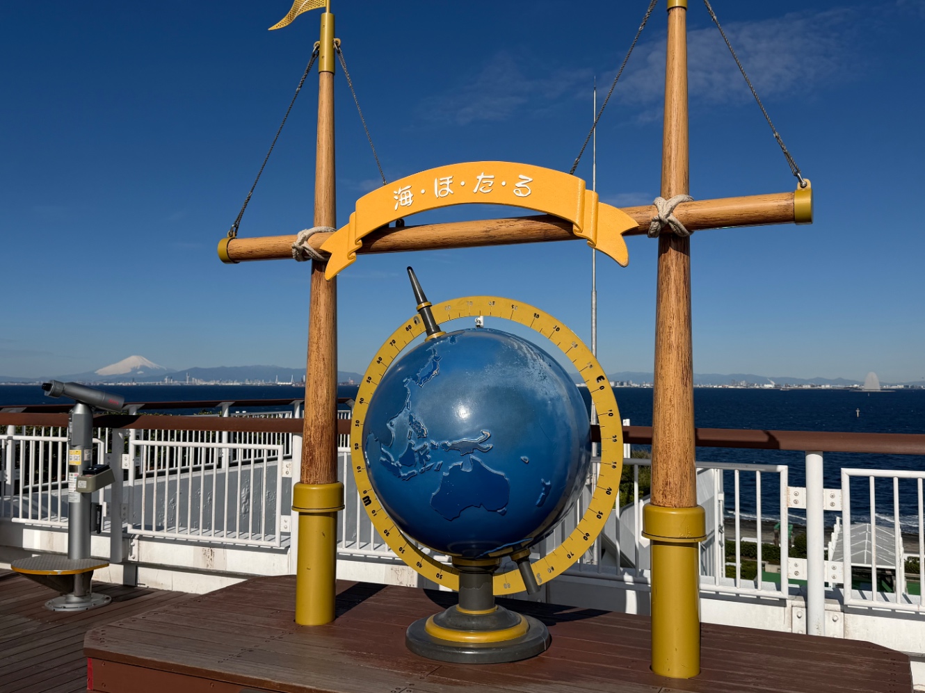 海ほたるパーキングエリアの地球のモニュメント 背後に富士山が写っている