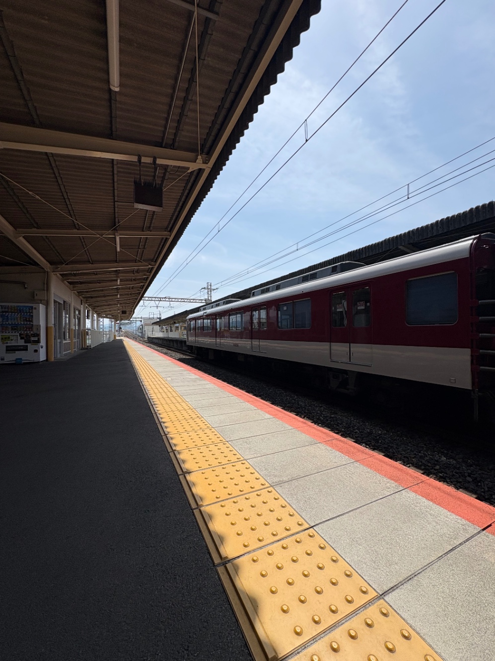 無人の駅のホーム。反対方向（上り）のホームに電車が入っている