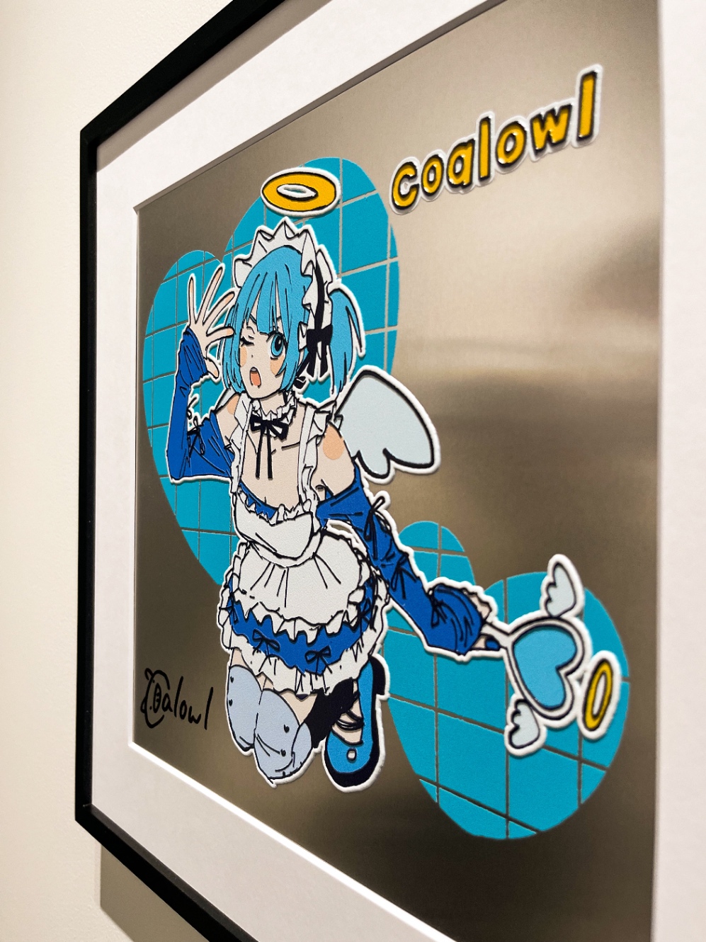 展示作品を斜めから撮った写真。金属のキャンバスに、水色の髪の天使のイラストが描かれている。エンボス加工したように立体的になっていて、奥行きがある。