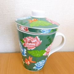 KALDIの茶こしつきマグカップ。セージグリーンのカラーにピンクと薄い青色の花と黒と赤の金魚が泳いでいる模様が描かれている