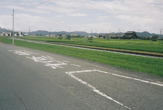 田舎の道路の写真。減速 と書いてある。