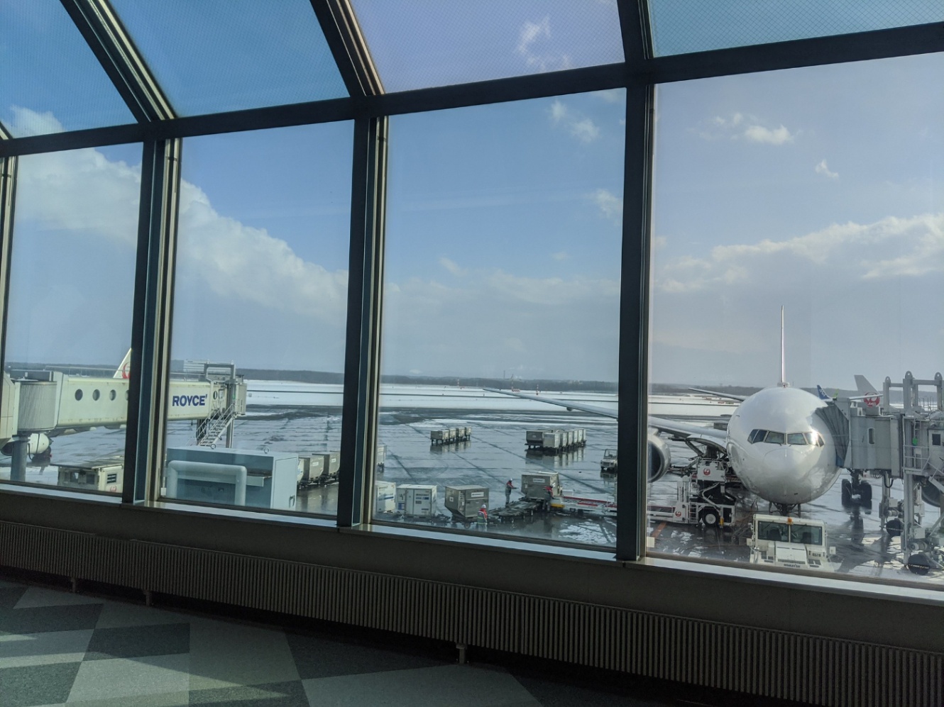 空港の待合室から飛行機が待機している様子を写した写真